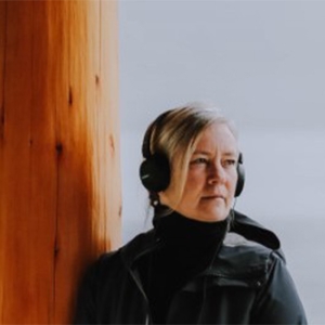 Laura Palmer Laura Palmer, wearing headphones, looks out at a grey ocean.