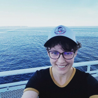 Allison on a boat, wearing a Ginger Goodwin baseball hat