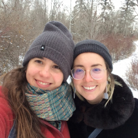 Kendra & Maria stand next to each other in the snow, taking a selfie