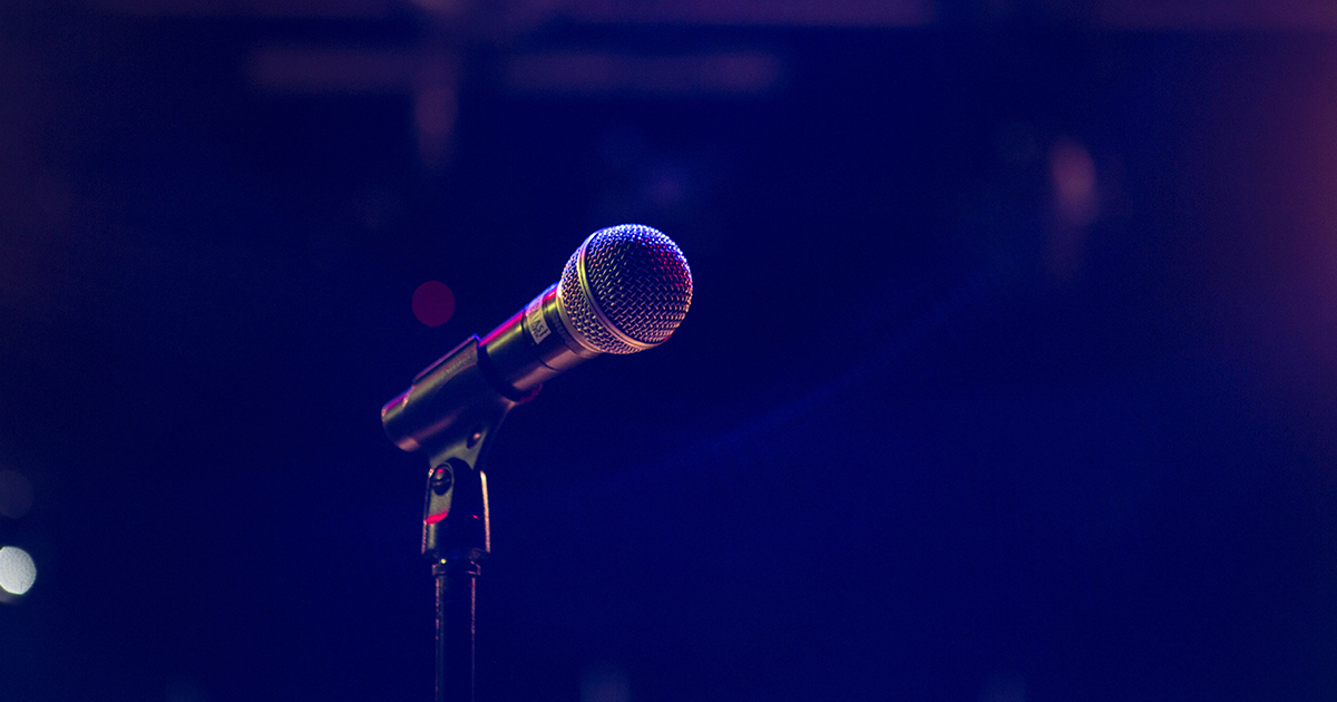 A closeup of a microphone on an empty stage