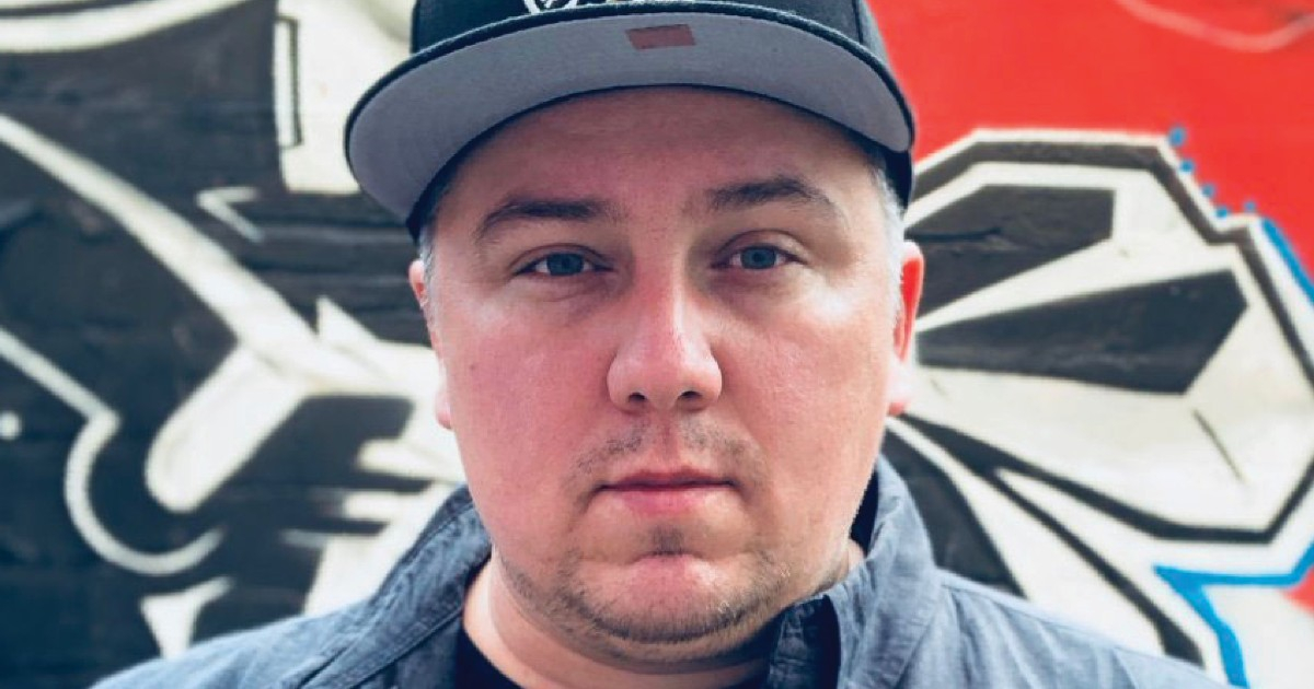 Close up of Ryan in front of a graffiti wall